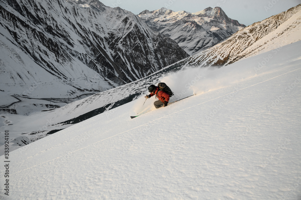 man performs freeride skiing on snow-capped mountains. man performs freeride skiing on snow-capped mountains.