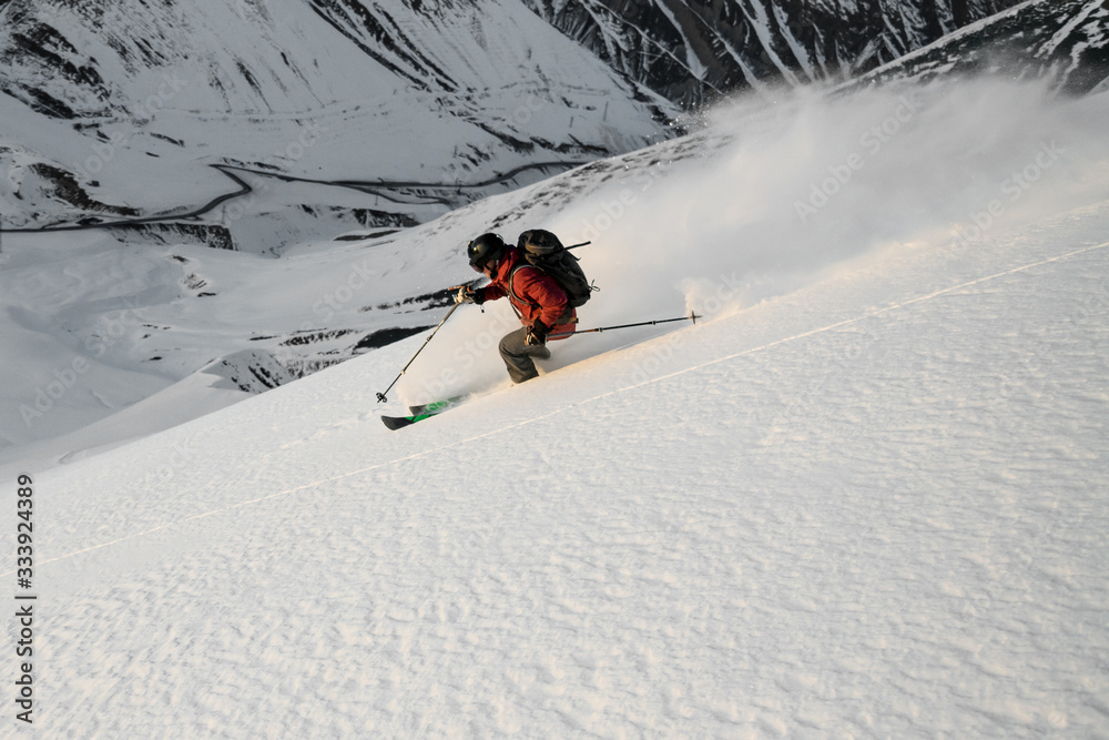 Skier descends on snowy slope of mountain