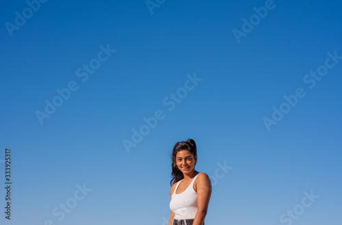 Smiling young lady against clear blue sky © rushay