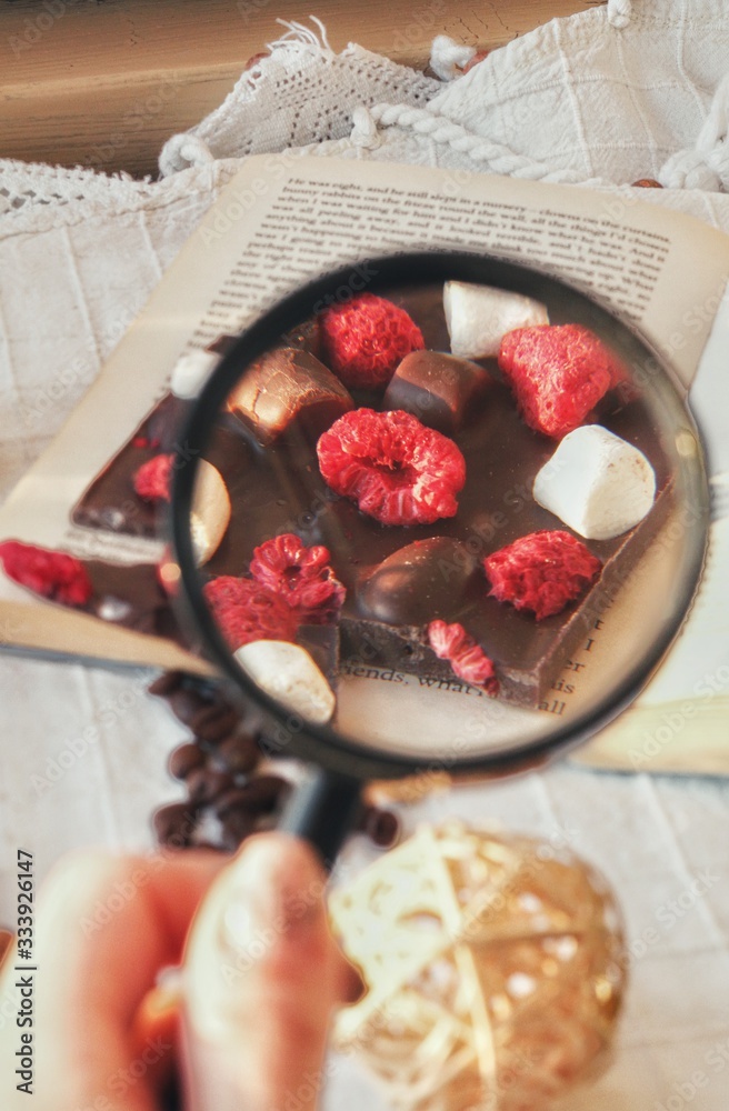 Crafted handmade chocolate bar with marshmallow and berries, coffee beans and good book