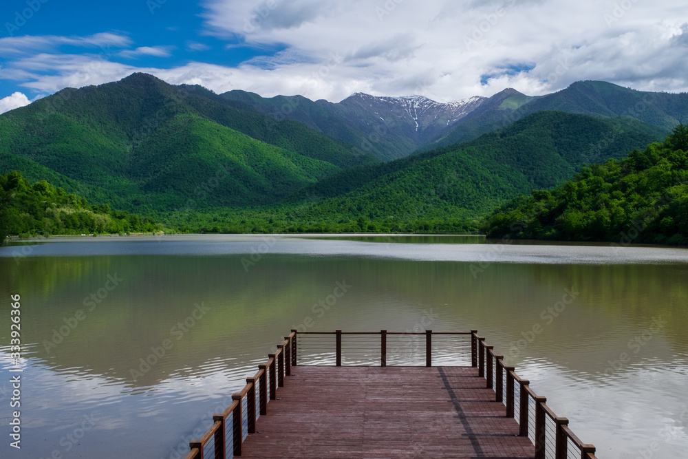 Pier on the lake on a background of mountains and blue sky