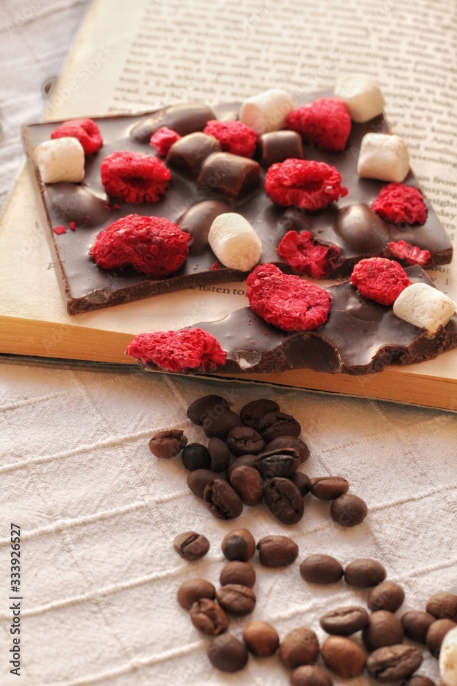 Crafted handmade chocolate bar with marshmallow and berries, coffee beans and good book