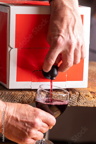 pouring red wine from a box