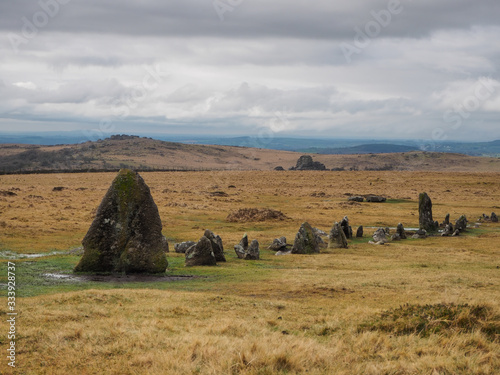 Bronze Age standing Stone Rows at Merrivale Prehistoric site with Vixen Tor in the background and storm clouds overhead, Dartmoor National Park, Devon, UK