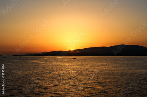 a sunset above the sea in the resort town of Gelendzhik, the sun is gradually left behind mountains. Black sea coast