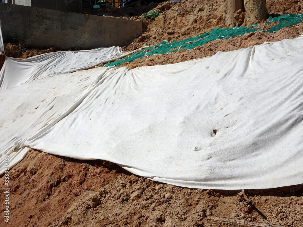 The geotextile fabric is spread over the surface of the slope to