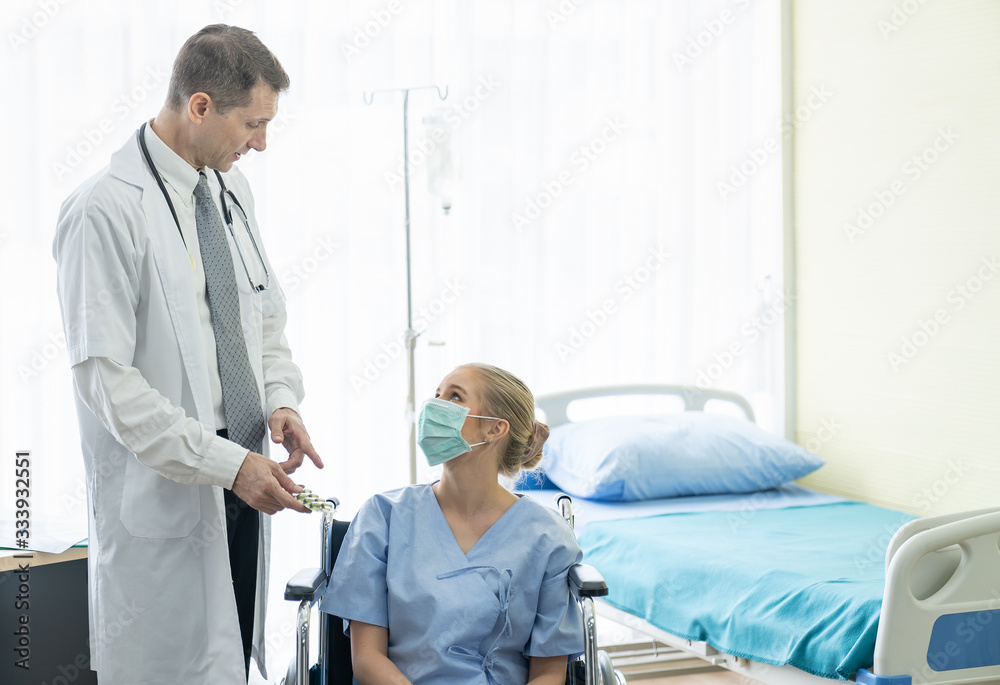 Fototapeta premium Senior doctor consults or discussing medicine to young patient woman put on a protective medical mask while sitting at the clinic or hospital. Medicine and Healthcare concept. Doctor and patient