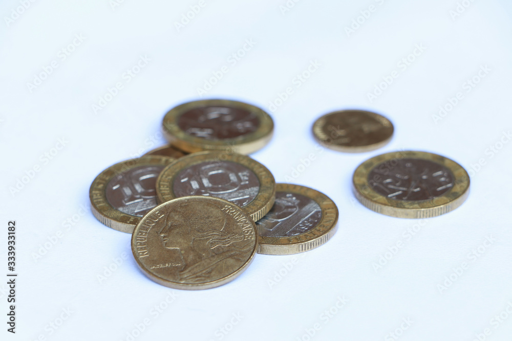 Heap of French franc coin money on the white background. Concept of finance.