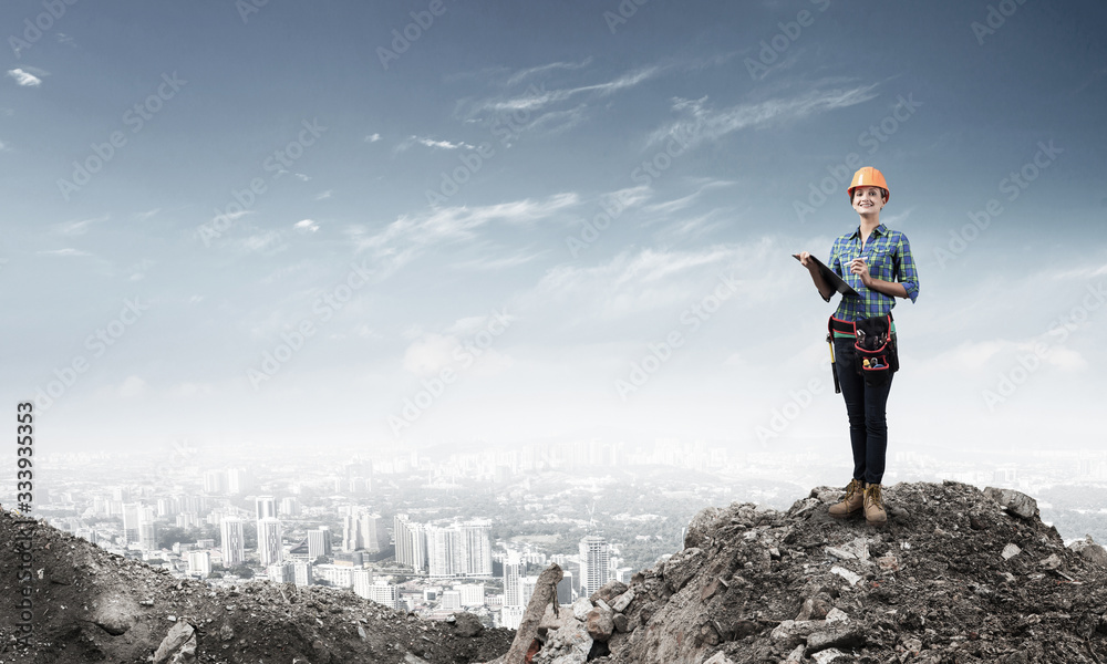 Young engineer in hardhat standing in front Young engineer in hardhat standing in front