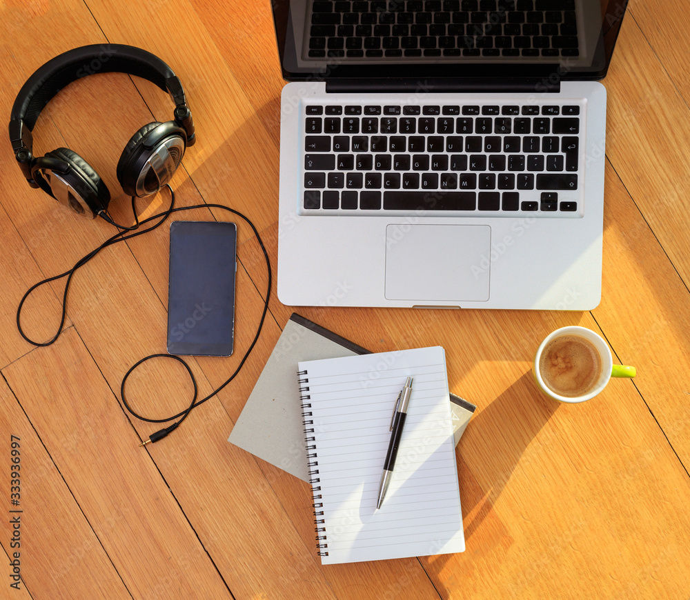 Work from home. Computer laptop, mobile phone, headphones on the floor Work from home. Computer laptop, mobile phone, headphones on the floor
