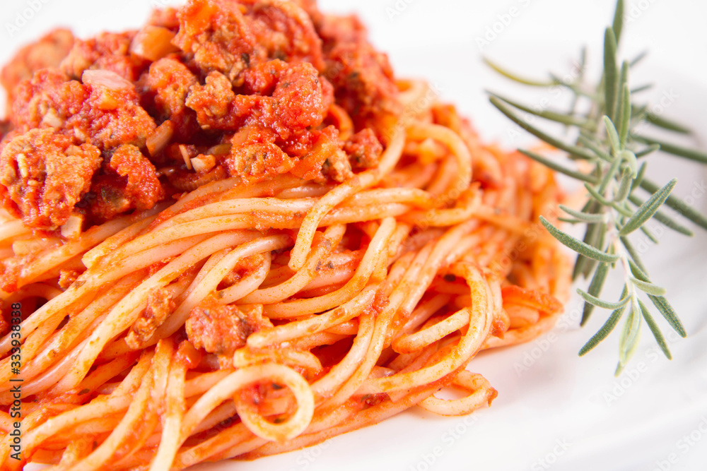Spaghetti bolognese on a plate decorated with a rosemary twig Spaghetti bolognese on a plate decorated with a rosemary twig