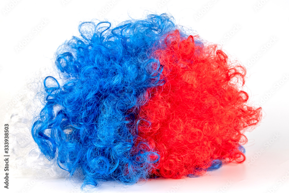 Multi-colored clown wig Isolated on a white background. The concept of humor, performance. Multi-colored clown wig Isolated on a white background. The concept of humor, performance.