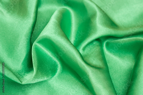 Smooth elegant green silk or satin luxury cloth texture can be used as an abstract background. Crumpled fabric.
