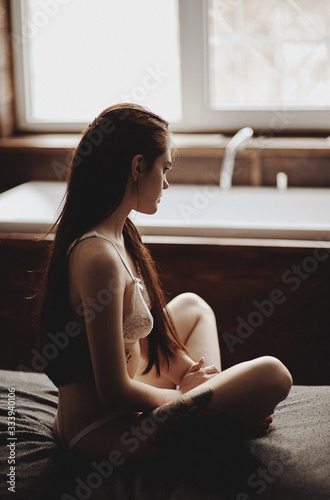 Beautiful, young girl of European appearance, subdued light, soft focus. Apartments.