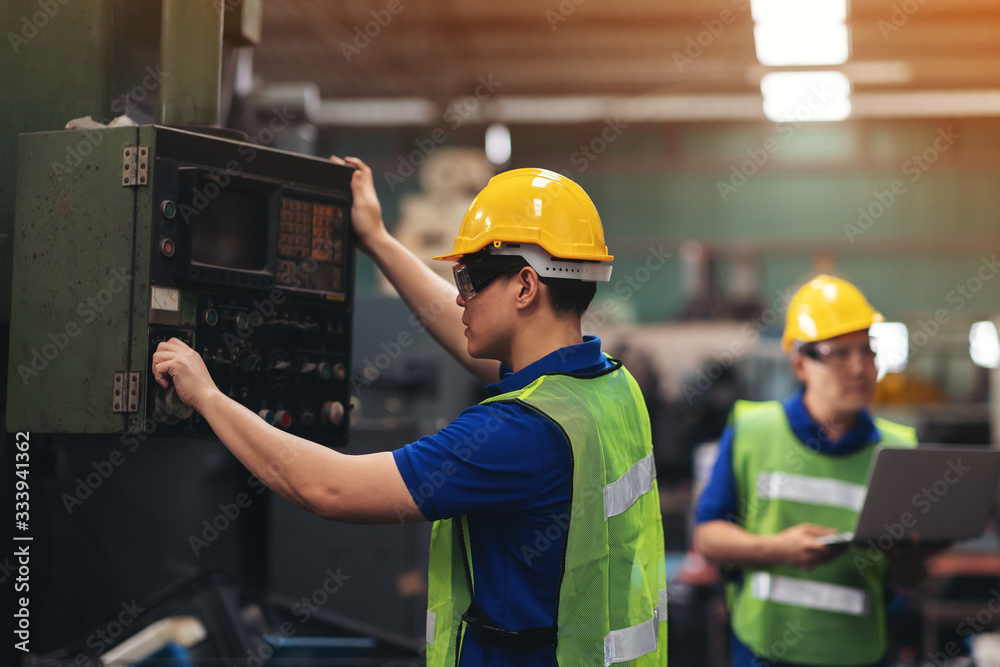 Industrial worker in hard hat are working on production machinery in the factory. Industrial worker in hard hat are working on production machinery in the factory.