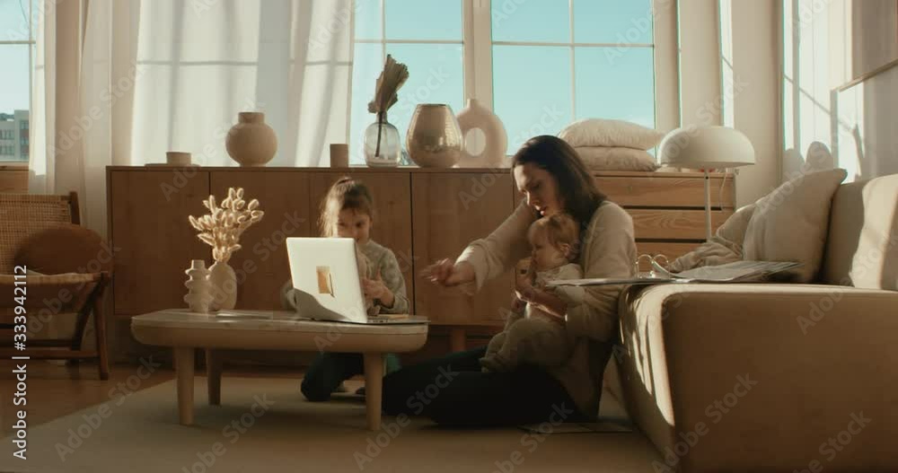 Mother working from home, having a phone call, while her daughters distract her and drawing attention. Shot on RED Dragon Mother working from home, having a phone call, while her daughters distract her and drawing attention. Shot on RED Dragon