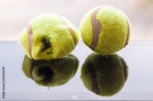 torn and whole tennis ball