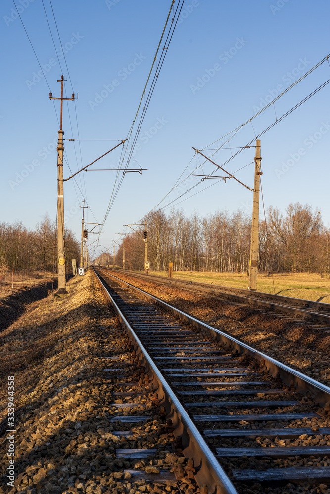 Railway with semaphore and electric poles.