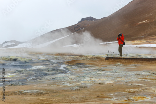 A man stands near a geothermal source. Sulfur vapor in Iceland
