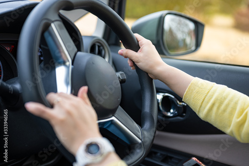 車の運転をする女性、ハンドルを握る手
