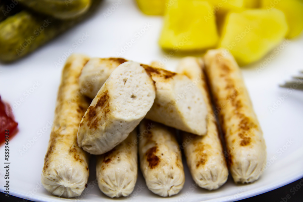 Delicious homemade chicken sausages boiled and made on the fire. Fragrant sausages made from non-GMO chicken. Toasted Mini Sausages from chicken on the plate Delicious homemade chicken sausages boiled and made on the fire. Fragrant sausages made from non-GMO chicken. Toasted Mini Sausages from chicken on the plate