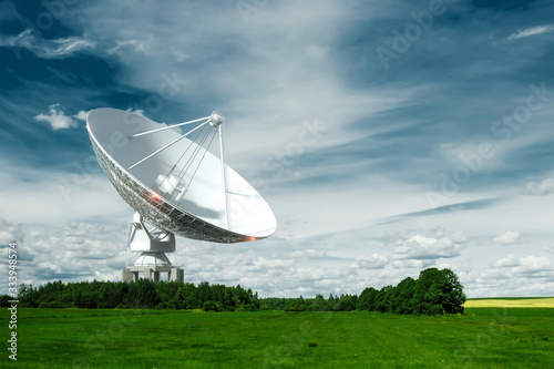 White Radio Telescope, a large satellite dish on a background of blue sky, radar. Technology concept, search for extraterrestrial life, wiretap of space. Mixed medium, copy space.