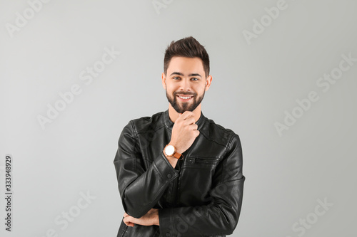 Handsome man with healthy hair on light background