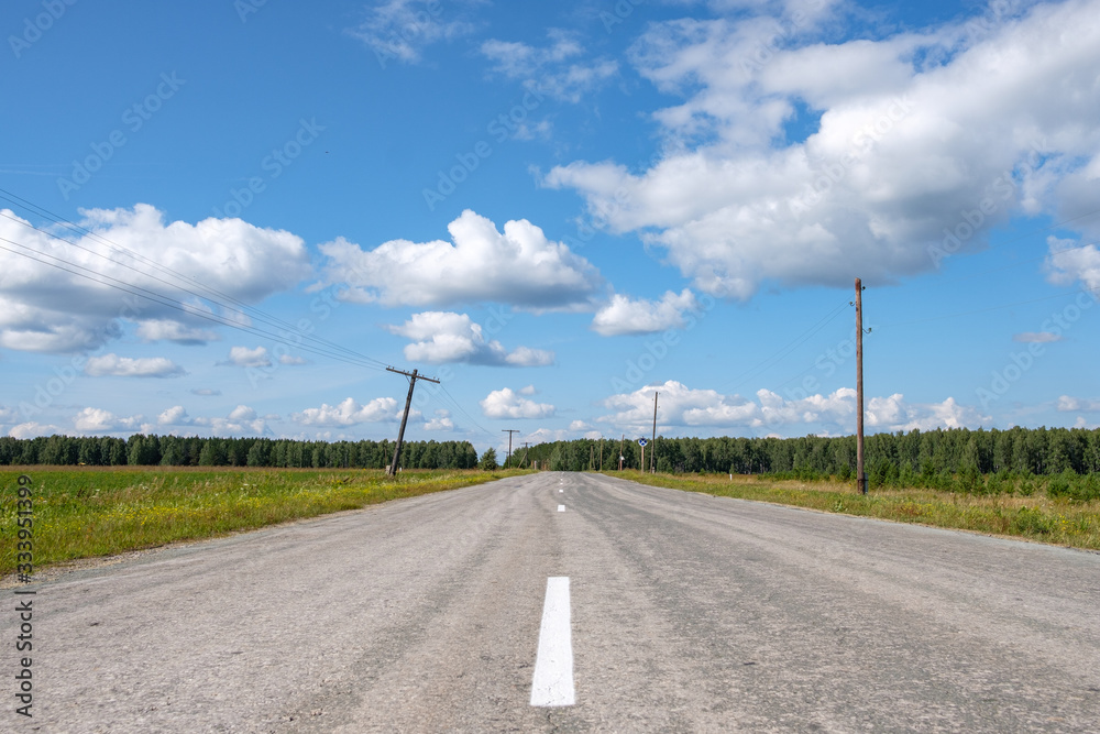 road with poor asphalt on the side of the rickety electric poles