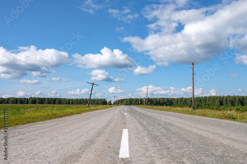 road with poor asphalt on the side of the rickety electric poles © metelevan