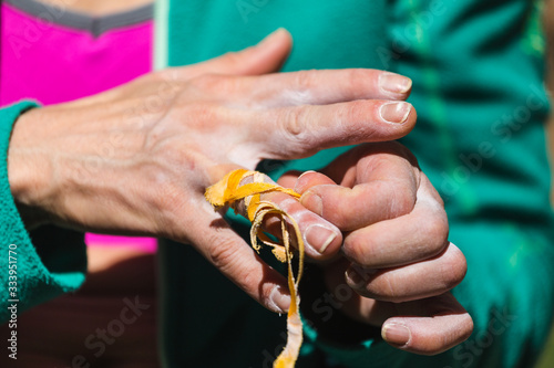 Rock climber bandages his fingers with a protection tape.