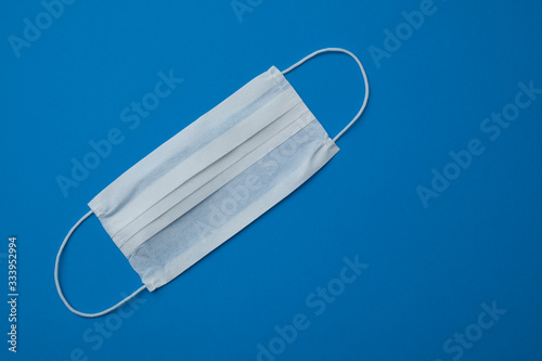 facial disposable medical mask isolated on blue background.