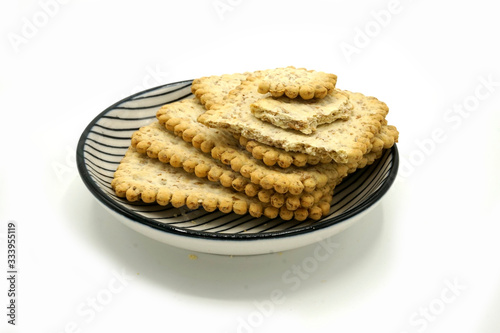 Dried fruits and digestive biscuits on a ceramic saucer isolated on white background. Energy and fiber natural source. Dieting food. photo