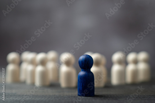 Wooden figure standing in front of the team to show influence and empowerment. Concept of business leadership for leader team, successful competition winner and Leader with influence photo