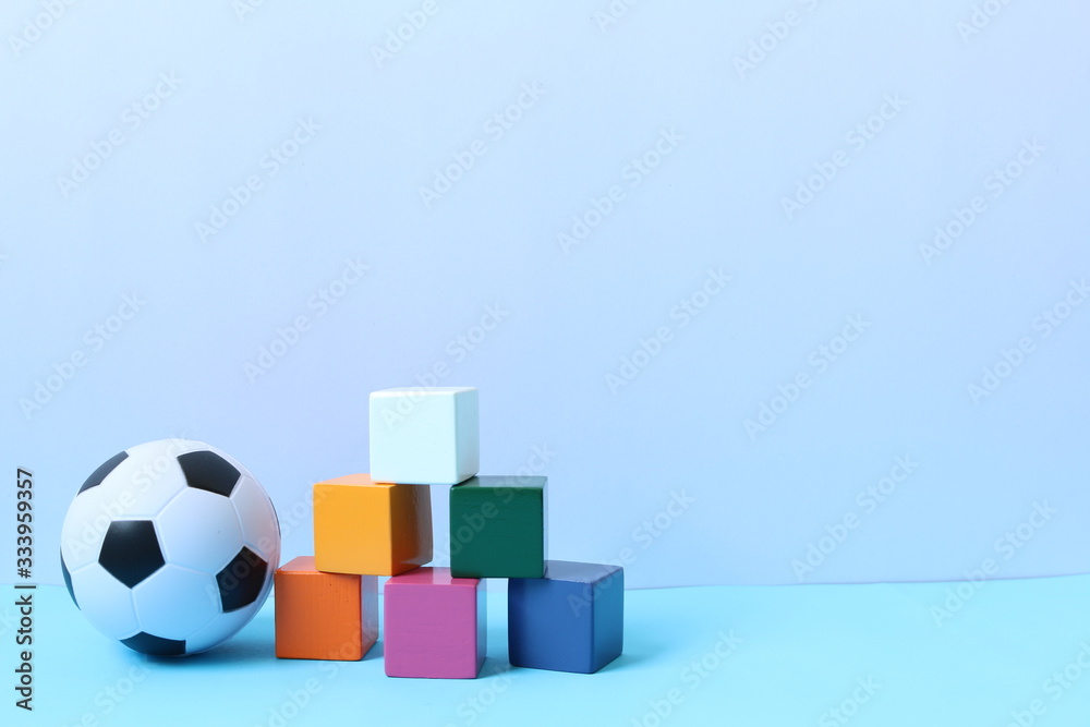 Obraz premium Children's toys collection. Toys collection on blue background. Education and learning concept. Kids toys frame background. Copy space for text. Ball, colored wooden block set, car and tank