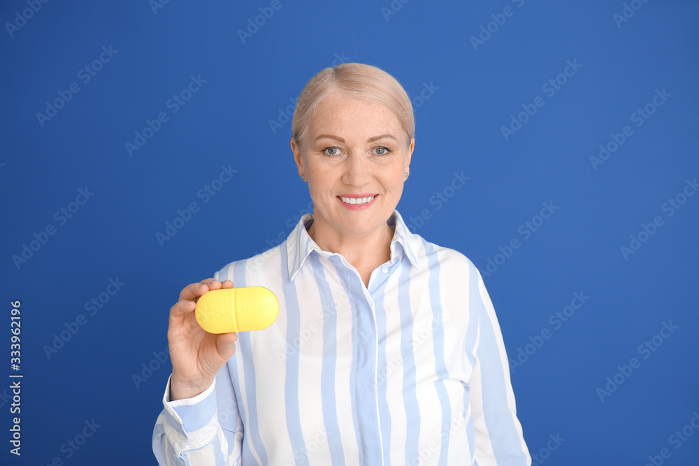 Mature woman with pills box on color background Mature woman with pills box on color background