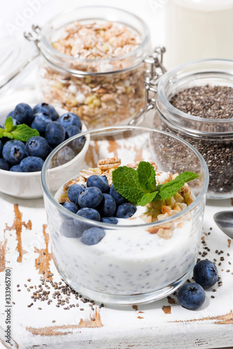healthy breakfast with chia-pudding and fresh blueberries on white board, vertical closeup