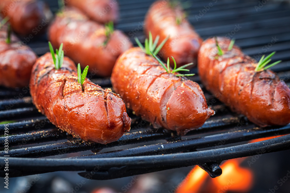 Closeup of delicious sausage on grill with spices and herbs