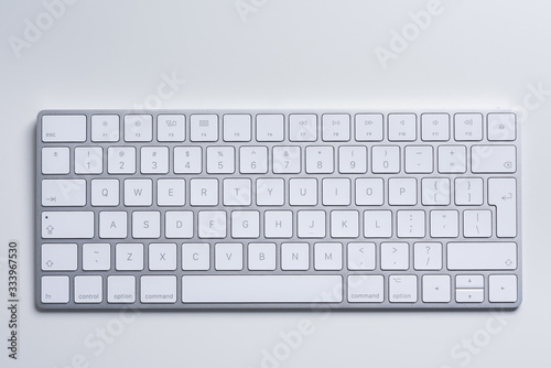 Computers. White minimalistic aluminium keyboard on a white table. Closeup