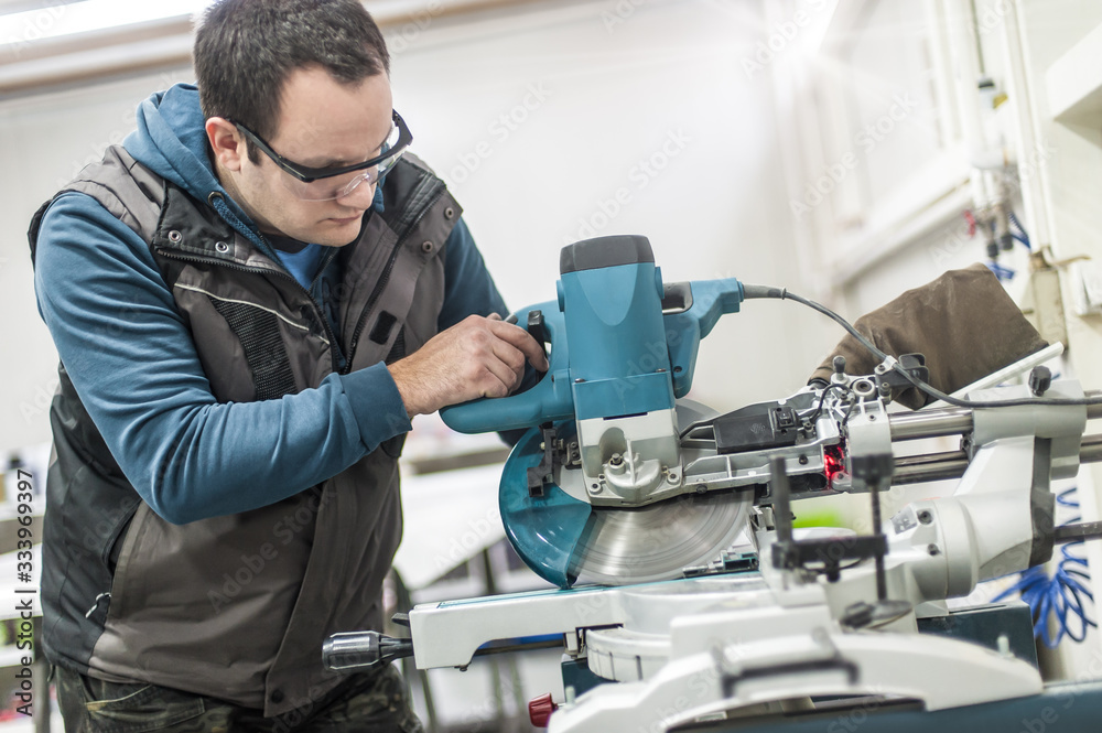 Worker technician works with electric wheel grinding on steel structure