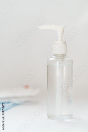 Antibacterial Hand Sanitizer Gel Blank Bottle Closeup Copy Space Vertical Photo. Container Antiseptic High Alcohol Liquid, Blurred Protective Gauze Dressing on Background. Coronavirus Covid-19 Disease