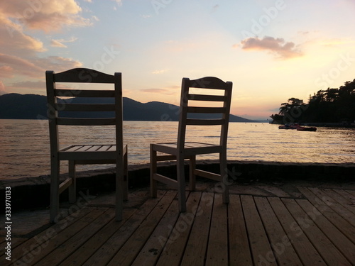 the two empty chair at the sunset between the coast