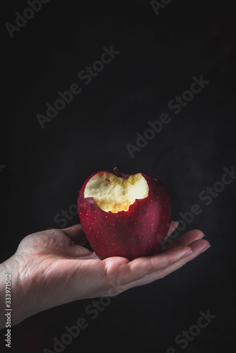 A red apple hold in a hand