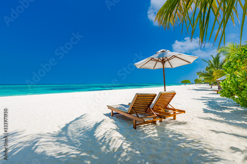 Fototapeta Naklejka Na Ścianę i Meble -  Luxury beach resort, beach loungers near the sea with white sand over sea Topical island background, summer vacation concept, holiday and tourism design. Exotic landscape, inspirational leisure banner