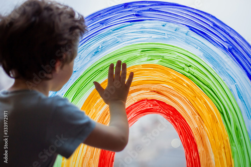 let's all be well. child at home draws a rainbow on the window. Flash mob society community on self-isolation quarantine pandemic coronavirus. Children create artist paints creativity vacation