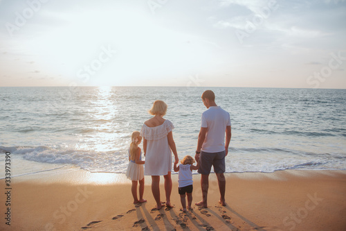 Holiday travel concept, Summer vacations. Happy family are having fun on a tropical beach in sunset.