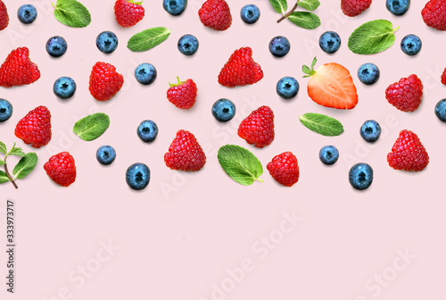 Fresh berry and fruit mix border frame banner of ripe berries and mint leaves on pink background. Flat lay. Fruit pattern