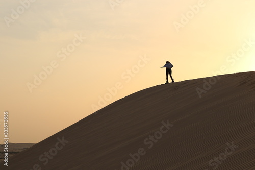 Sandboard in dune at sunset