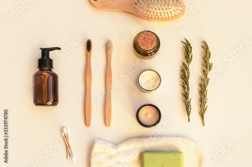 Natural cosmetics, soap, wooden toothbrushes, cosmetic mittens, comb and sprigs of rosemary on a white table. Beauty, spa and wellness concept. Top view, flat lay, copy space.