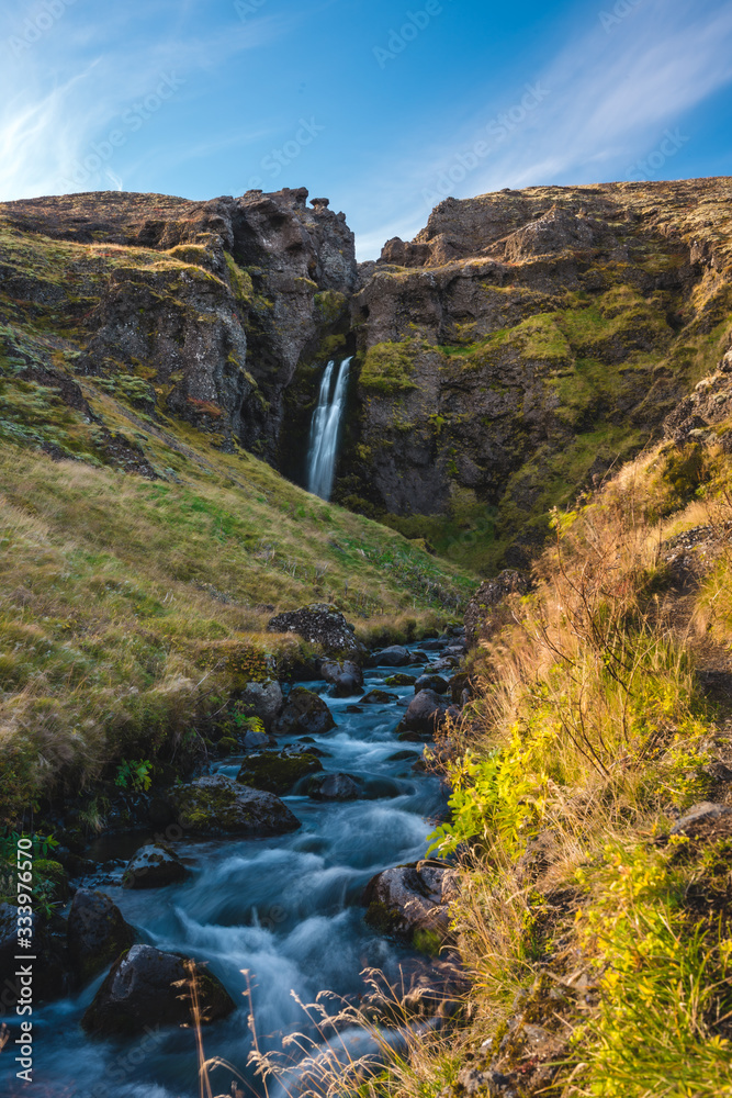 Image of Beautiful Waterfall in Iceland with unique rough landscape taken during bright sunny weather Image of Beautiful Waterfall in Iceland with unique rough landscape taken during bright sunny weather