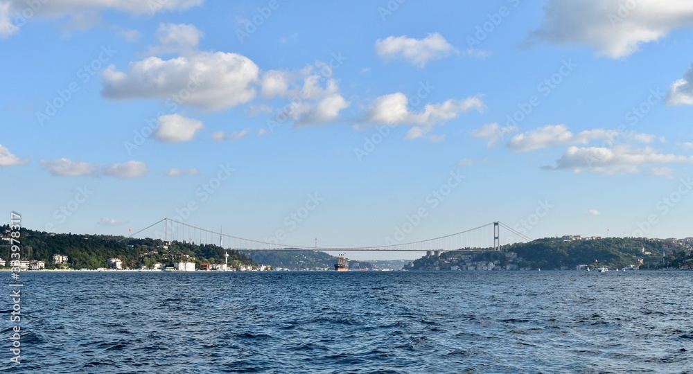 Commercial vessel is passing under Istanbul Bosporus Bridge in a nice summer day